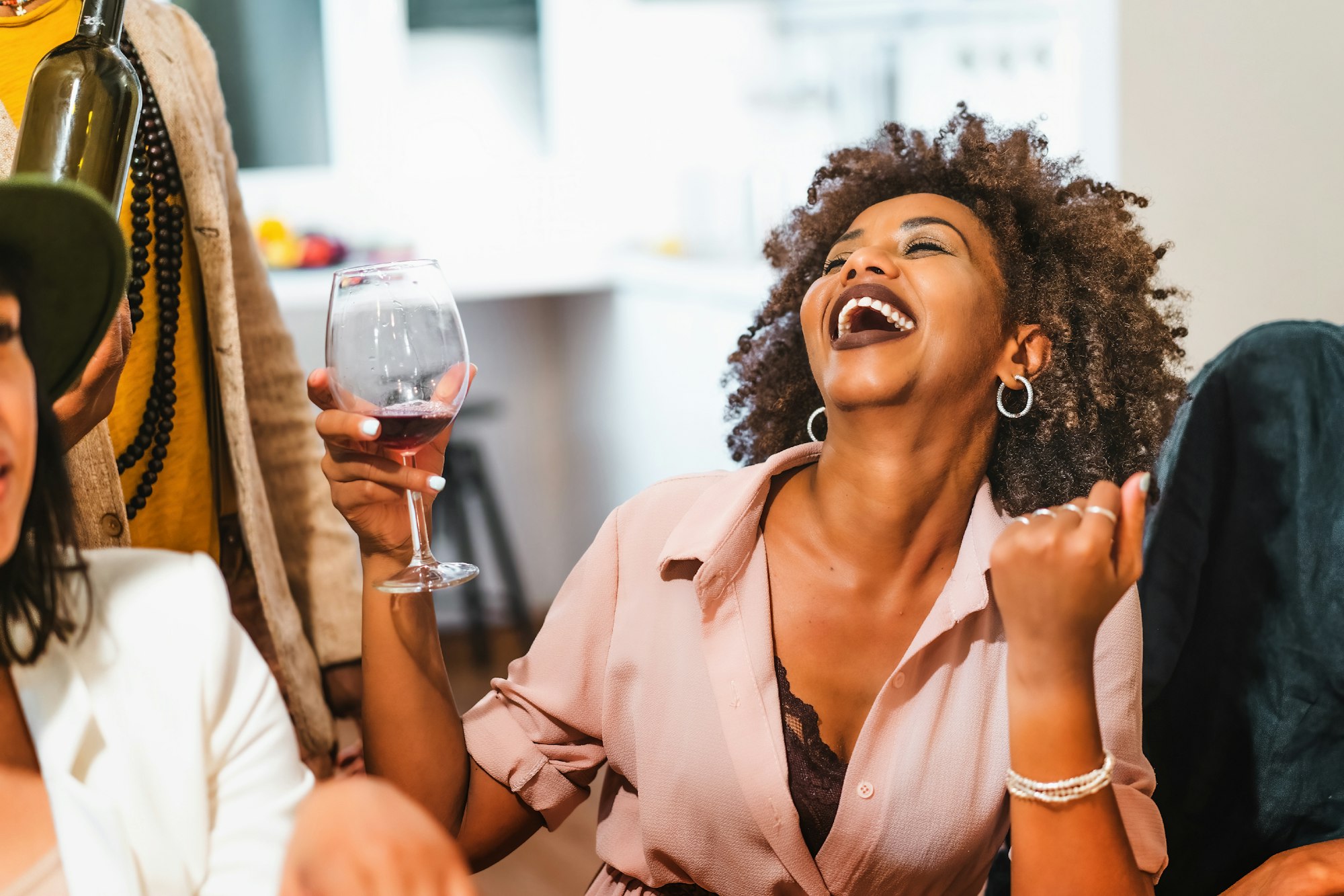 Portrait of an African American woman laughing drinking wine